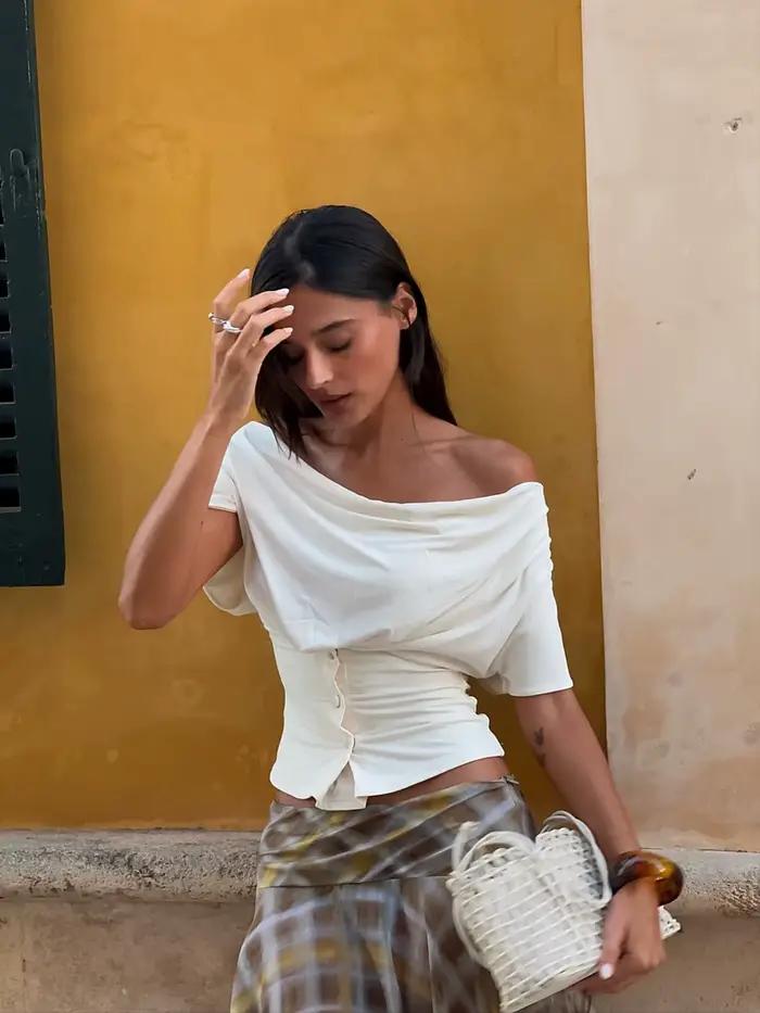 T-shirt beige en jean à taille cintrée, haut noir asymétrique à une épaule et manches courtes